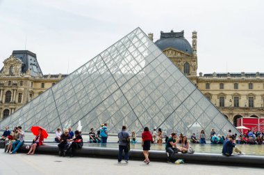 Paris 'teki Louvre Müzesi' nin gece manzarasının keyfini çıkaran insanlar