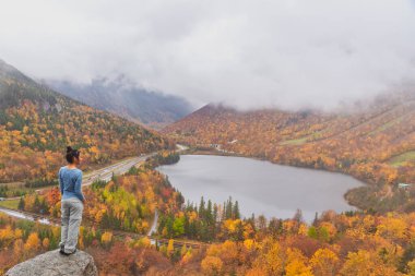 New Hampshire 'daki Artists Bluff Loop' tan Echo Lake 'in önünde poz veren kadın.