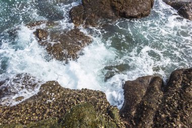 Üst manzara deniz dalgaları kayalıklarda kırılıyor