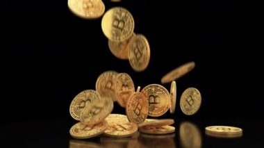 Altın bitcoins ağır çekim yığının üstüne düşmek. Altın sikke üzerinde siyah arka plan 4 k slowmotion alfa kanalı ile video düşüyor. Cryptocurrency incelemesi kavramı.
