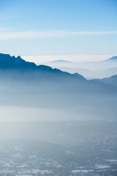 Beaux Alpes françaises hiver panoramique vue aérienne paysage avec un fantastique brouillard bleu nuageux fond de montagne Image En Vente