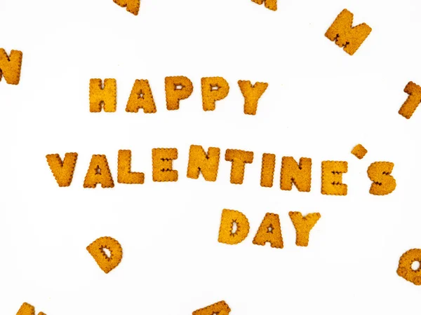 "Joyeux Saint-Valentin "phrase faite de lettres de cookies. Fond blanc, biscuits autour de l'inscription . — Photo