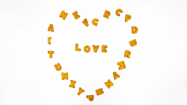Λέξη "αγάπη" και καρδιά φτιαγμένη από γράμματα μπισκότων με λευκό φόντο. — Φωτογραφία Αρχείου