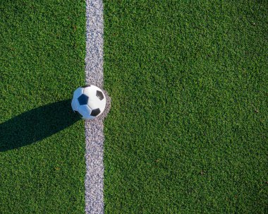 Yukarıdan vurulmuş. Maç başlamadan önce yeşil futbol sahasındaki beyaz çizginin ortasındaki top..