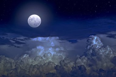 Gece gökyüzünde bulutlar arasında dolunay