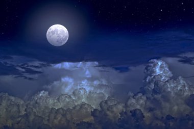 The full moon between the clouds in the night sky clipart