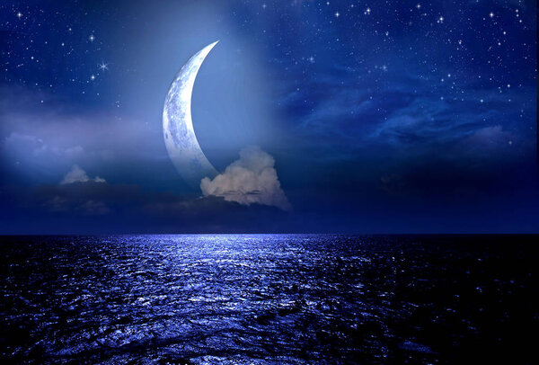 Crescent moon over the sea at night