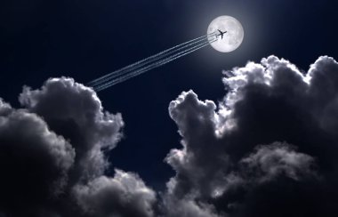 Jet uçağı ve iz dolunayın arka planında.