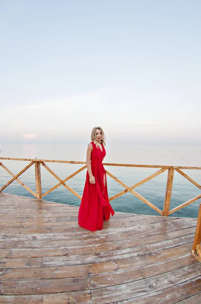 Чарівна Дівчина Довгій Червоній Сукні Танцює Позує Пірсі Фоні Моря — стокове фото