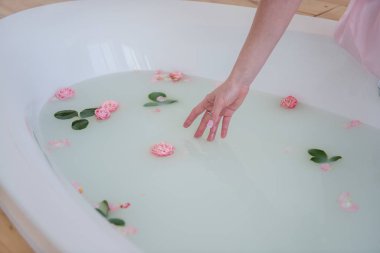 Sağlık spa tedavileri. Şifalı yağlarla dolu ve çiçeklerle süslenmiş bir küvet. Sağlık ve güzellik.