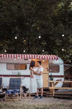 Genç bir çift karavanlarının arka planında sarılıyor. Aşıklar şehrin dışında dinlenir, doğada gülüp dans ederler. Beyaz uzun elbiseli bir kız, açık şortlu ve tişörtlü genç bir adam. Seyahat