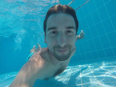 Genç adam suyun altına daldı. Suya daldırma