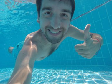 Genç adam suyun altına daldı. Suya daldırma