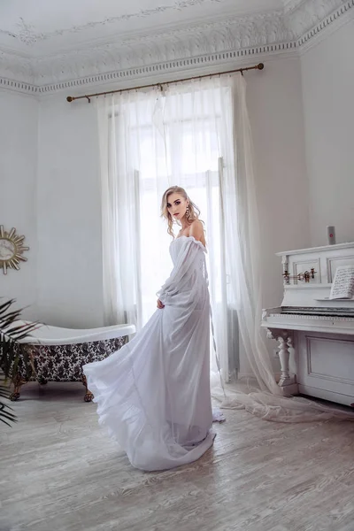 長い白いドレスを着た美しい花嫁が部屋を回っている どんな女の子にとっても大切な日です 花嫁の現代的なイメージ — ストック写真