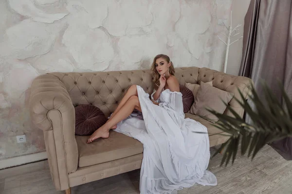 Moda Elbisesi Içinde Saçları Uzun Küpeleriyle Modern Bir Kanepede Oturan — Stok fotoğraf