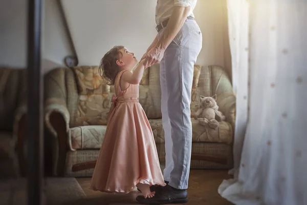 First daughter dance with dad. Little girl dancing on daddy\'s legs. Relations between dad and daughter.