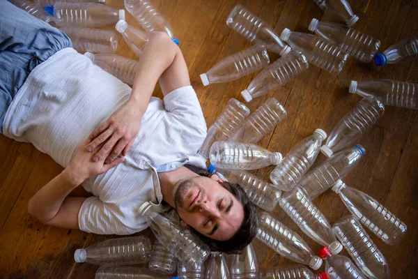 Mężczyzna Leży Wśród Plastikowych Butelek Nasz Otaczający Nas Plastikowy Świat — Zdjęcie stockowe