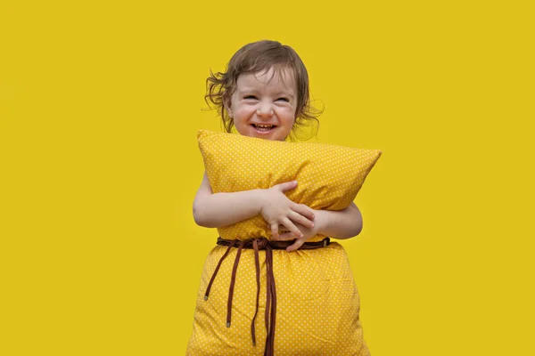 Piękna Dziewczynka Żółtą Poduszką Patrząca Kamerę Śmiejąca Się Przytulająca Poduszkę — Zdjęcie stockowe