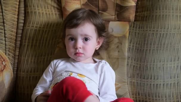 Una Niña Sienta Sofá Juega Teléfono Sonríe Niño Pasa Tiempo — Vídeos de Stock