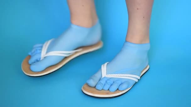 靴下と頁岩のように身を包んだ滅菌使い捨て手袋の女の子の足 この夏の傾向は ウイルスや真菌から足と体全体を保護する安全な旅行です コピースペース青の背景モックアップ — ストック動画