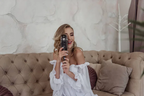 Красива Дівчина Білій Сукні Розважається Старою Камерою Дивані Наречена Позує — стокове фото