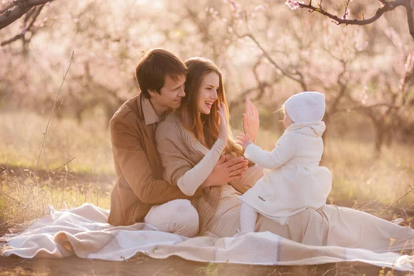Młoda Rodzina Kwitnących Ogrodach Tata Mama Trzymają Córeczkę Ramionach Miłość — Zdjęcie stockowe