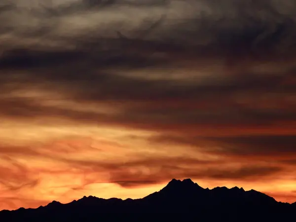 Olimpiyat Dağları üzerinde gün batımında karanlık gökyüzü, Seattle yakınlarındaki Shoreline, Washington 'daki Richmond Sahili' nden alınan Kardeşler Tepeleri de dahil olmak üzere..