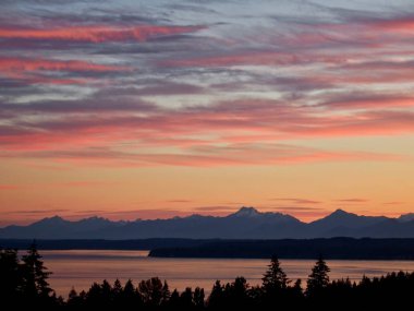 Puget Sound, Point Jefferson üzerinde Pastel gün batımı ve Seattle yakınlarındaki Washington, Shoreline 'den alınan Olympic Mountain sıradağları..