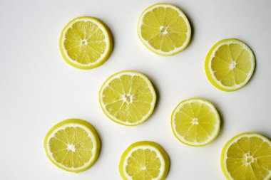 Limon dilimleri masanın ışık yüzeyinde rastgele yatar.. 