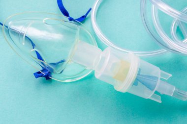 Mavi arka planda astım spreyinden bir maske. Tedavi amaçlı buhar solumak için bir cihaz.