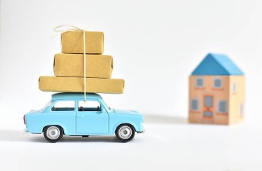 Vilnius, Litvanya, 18 Mart 2019: Ev taşıma konsepti, çatıda kutuları olan mavi oyuncak araba, yeni ev.
