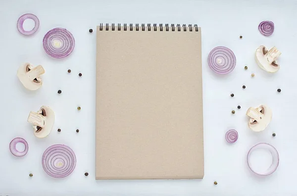 Blank notebook for recipe, mushrooms, onions, spices, top view. Menu mockup. Food blog background.