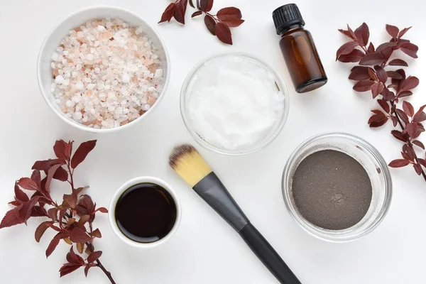 Natural skin care, beauty, spa products, essential oil, sea salt, coconut oil, flat lay on white background.