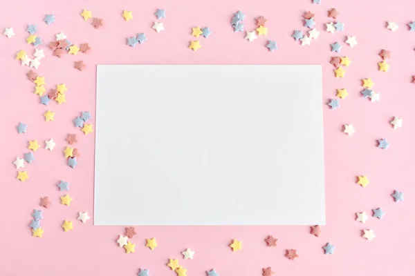 Greeting card mock up on pink background with colorful sugar stars, birthday party invitation.