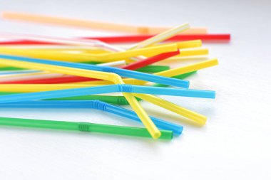 Beyaz masada renkli plastik pipetler.