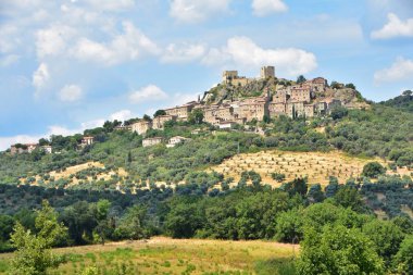 İtalya 'nın Montemmasi köyündeki şato harabeleri, dağlarla panoramik manzara, zeytin bahçeleri, tarım alanları, Toskana manzarası