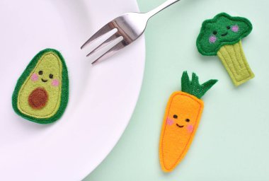 Sağlıklı beslenme, vejetaryen, vejetaryen ve el yapımı komik kawaii kumaştan yapılmış sebzelerle karşı karşıya..