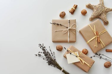 Çevre dostu el yapımı hediye paketi, lavanta dalları ve tarçın çubukları ile süslenmiş kutular, üst görünüm, kopyalama alanı.