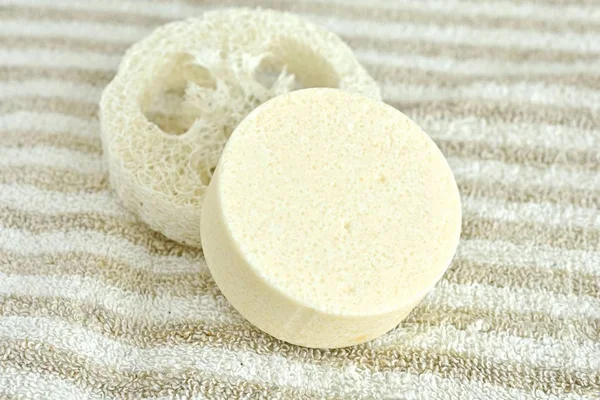 Close up view of solid shampoo bar made from natural ingredients on linen towel, no plastic, zero waste product