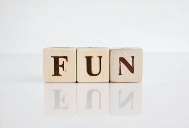 Sözcük eğlencesi ahşap küplerden yapılır, yansımalı beyaz arkaplan.