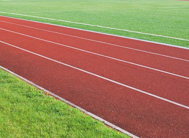 Stadyumda yeşil çimlerle koşuyor..