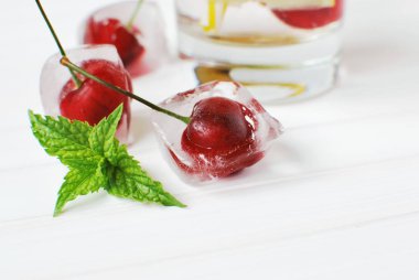 Soğuk yaz içeceği için buz küplerinde kiraz ve nane yaprakları..