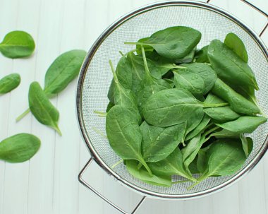 Kevgire bulanmış taze ıspanak. Beyaz ahşap masaya bakmak için.