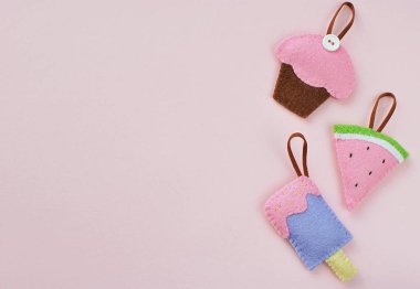 Pastel pembe arka planda yemek hissettim. Küçük şirin el sanatları, kek, karpuz, keçeli kumaştan yapılmış dondurma, metin için yeri olan düz bir yer..