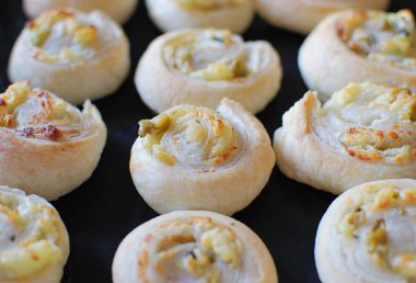 Siyah pasta tepsisinde ev yapımı puf böreği. İçindekiler - peynirli, sarımsaklı, zeytinli, otlu.