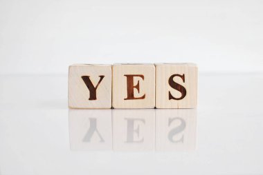 Sözcük Evet tahta bloklar üzerinde, yansımalı beyaz arkaplan