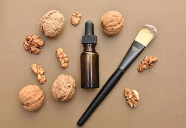 Walnut oil and brush on cosmetic pads, natural skin and hair care, beauty self care product, flat lay.