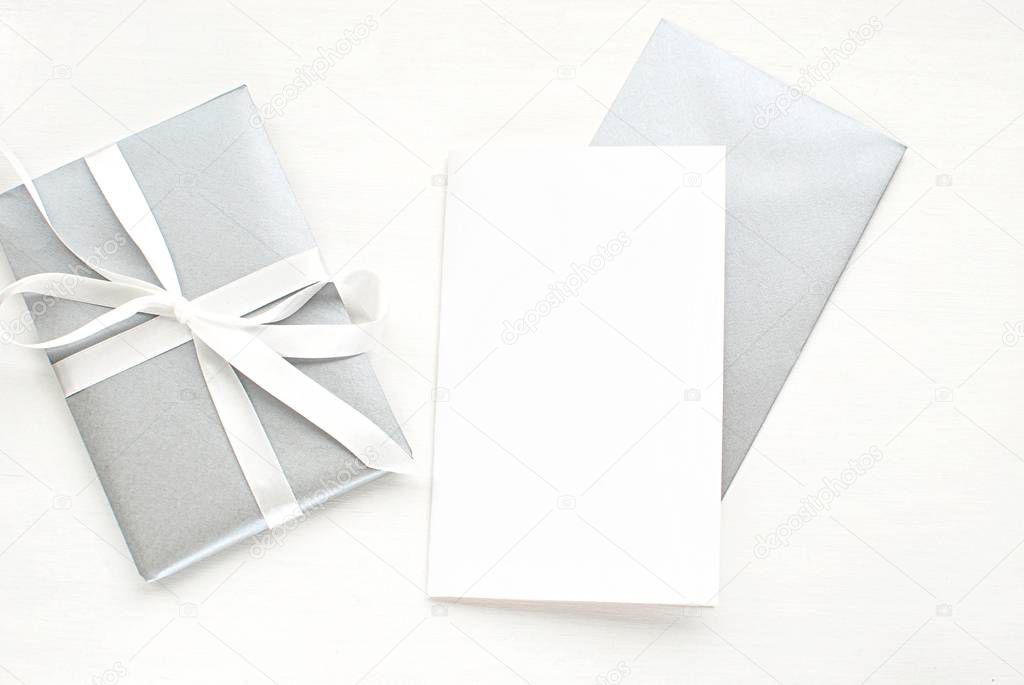 Modern flat lay with blank card and silver envelope, Christmas, New Years, wedding greeting card, invitation mock up.