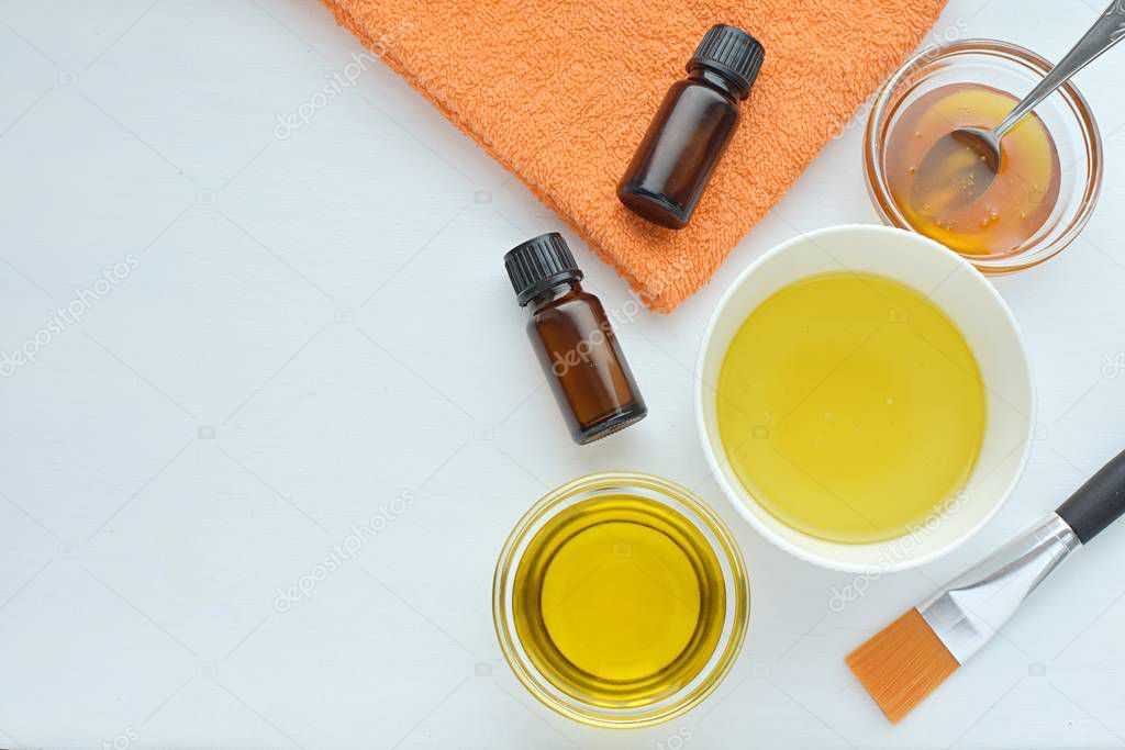 Natural cosmetics, homemade face or hair mask, olive oil, essential oils, honey, flat lay with copy space.