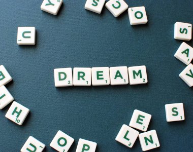 Yeşil arkaplanda kelime rüyası olan Scrabble oyunu harfleri.